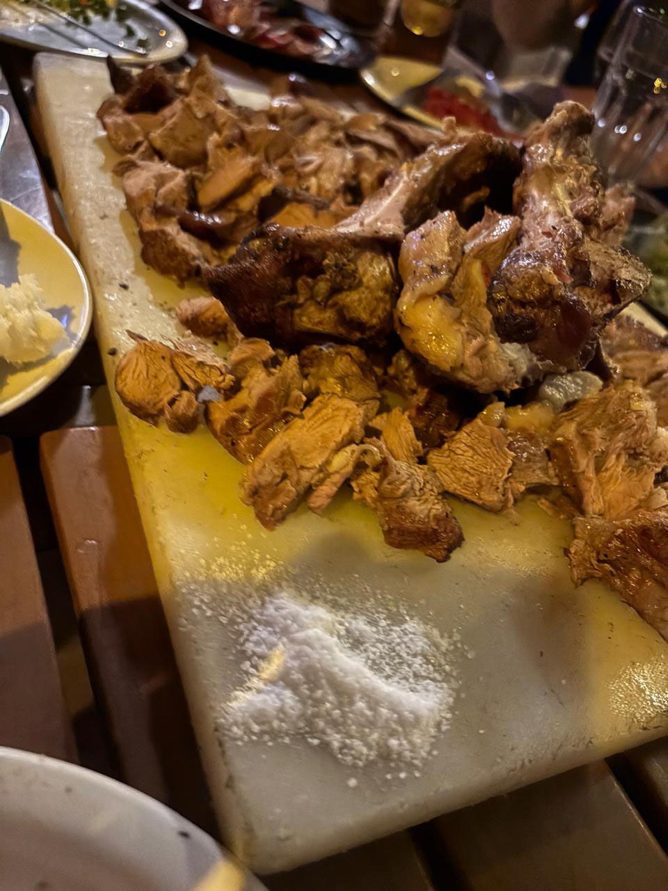 Close-up of Nyama Choma pieces served on a cutting board with coarse salt.