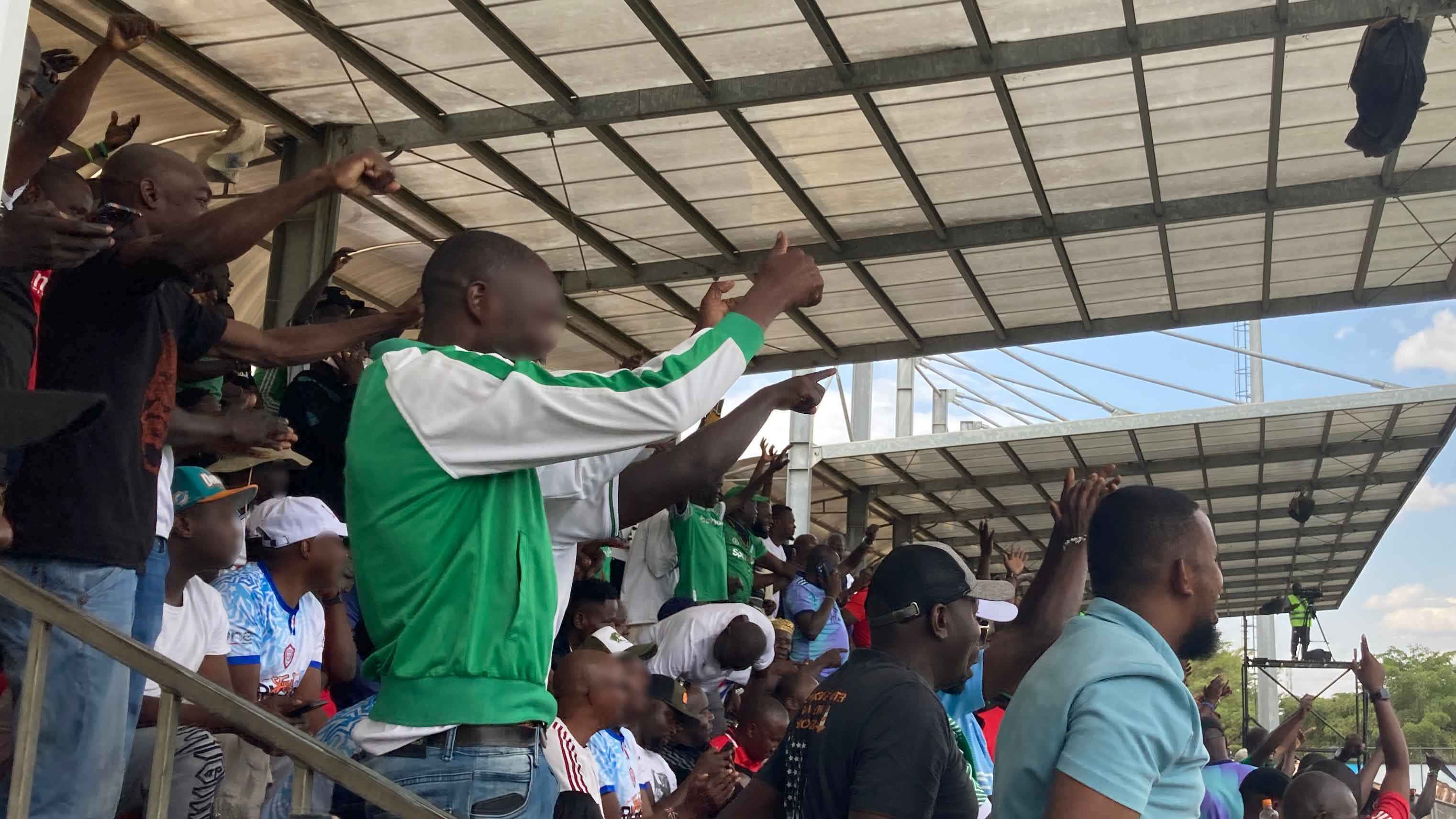 Excited fans cheering from the stands during the match.
