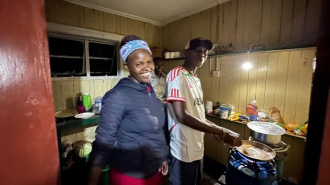 A serene high-altitude lake on Mount Kenya, reflecting the sky and clouds perfectly.