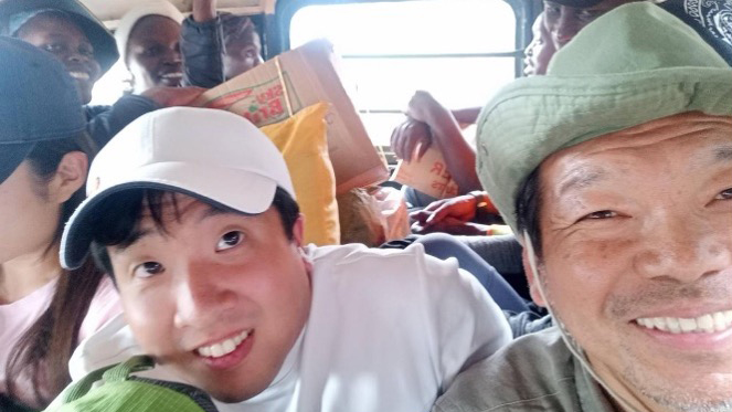 A group of people packed inside a local bus, smiling and enjoying the ride during their adventure.