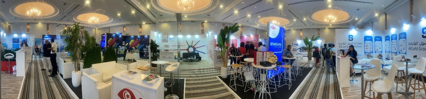 Wide-angle view of a bustling trade exhibition hall featuring multiple booths, including logistics, tech, and startup companies.