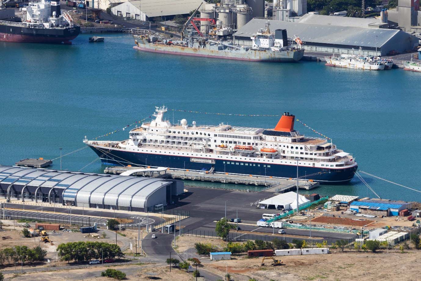 NIPPON MARU docked at Christian Decotter Cruise Terminal in Port Louis, Mauritius, surrounded by port infrastructure and warehouses.