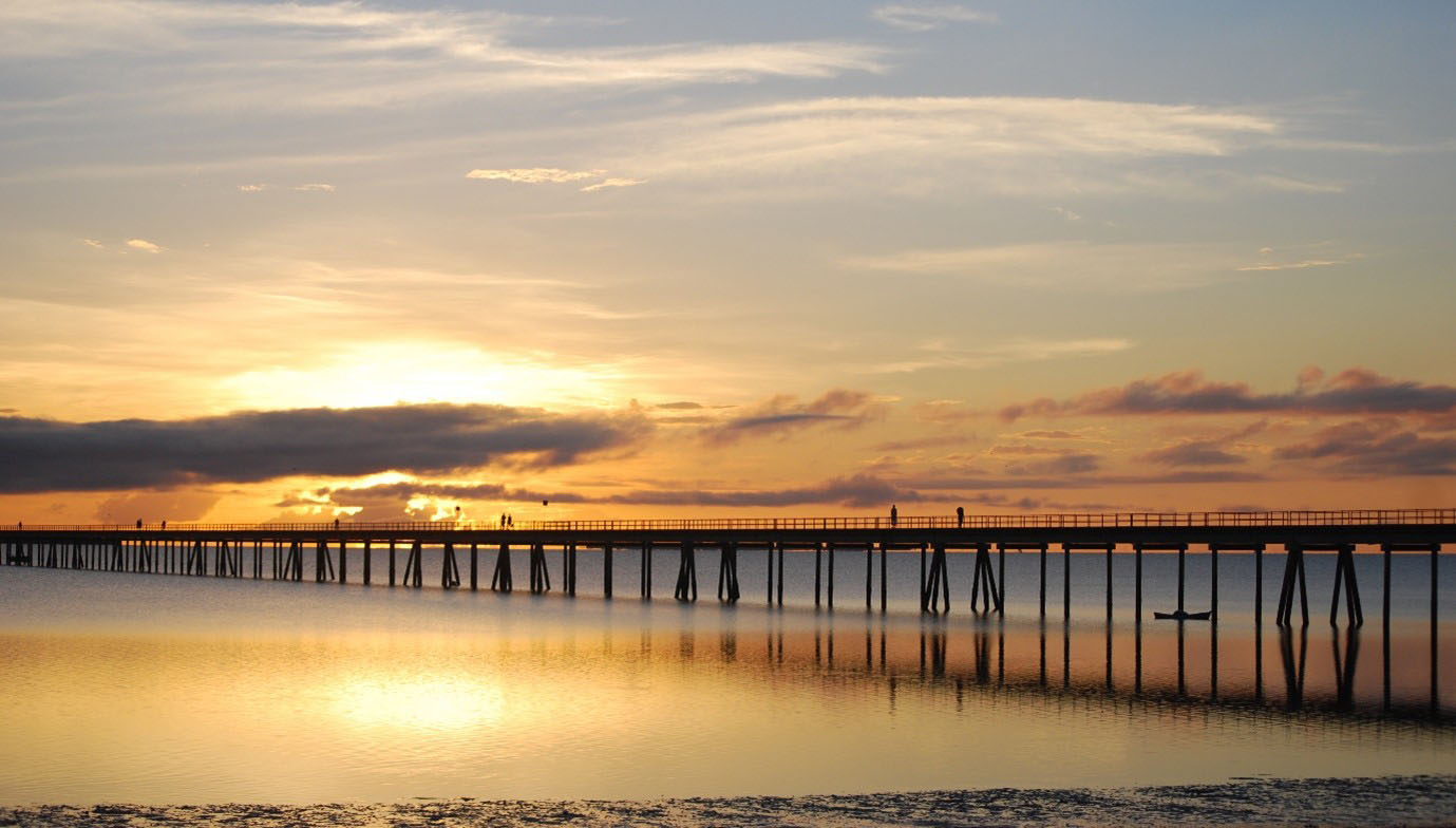 Sunset view of the 3-kilometer bridge connecting Ilha de Moçambique to the mainland, reflecting over calm waters.