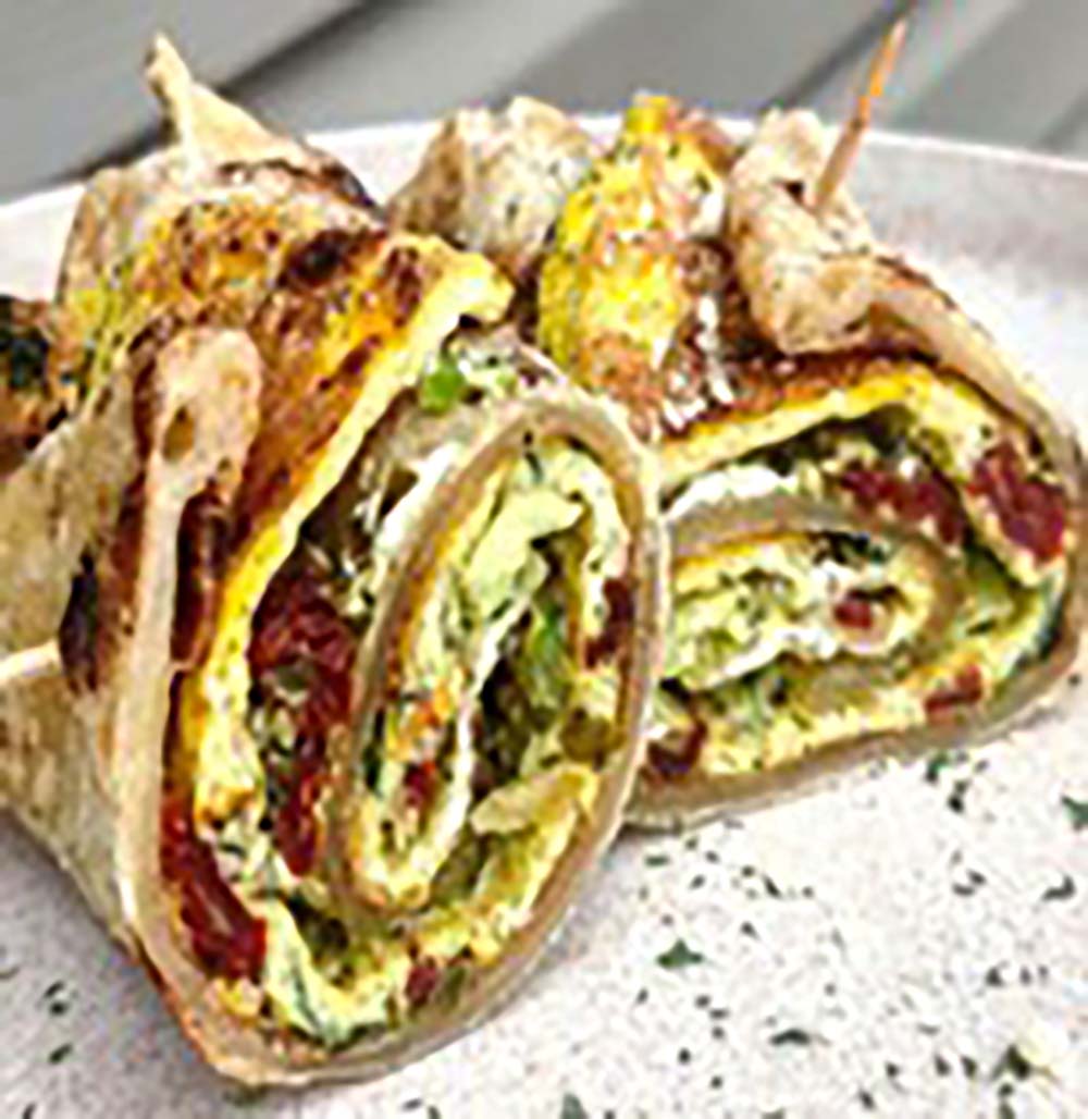 Rolled chapati with an omelette and vegetables, sliced to show the layered filling.