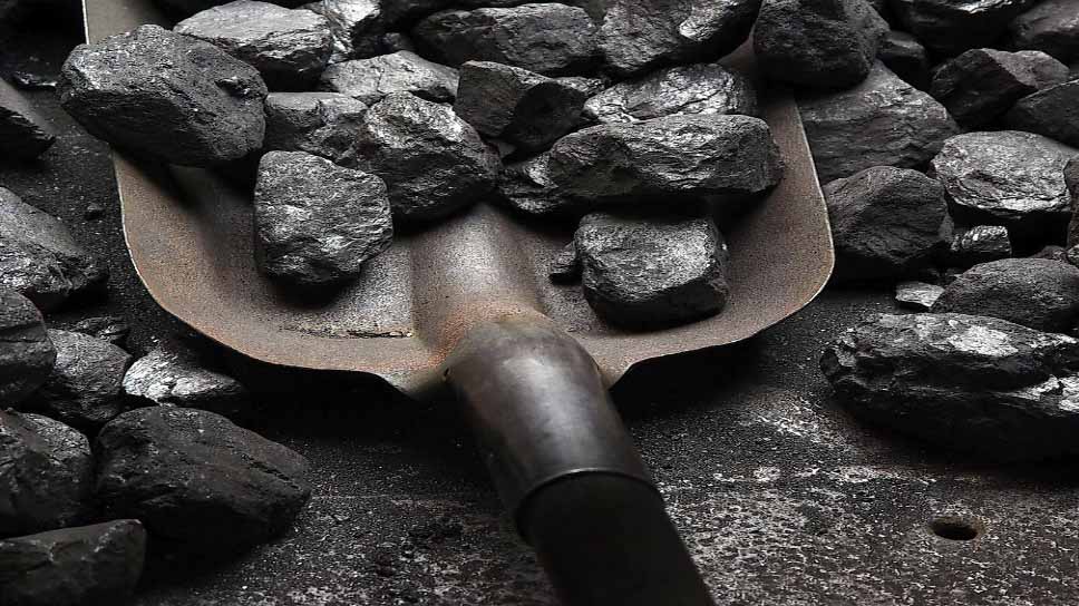 Close-up of coal pieces on a shovel, representing Mozambique’s coal mining and export industry.