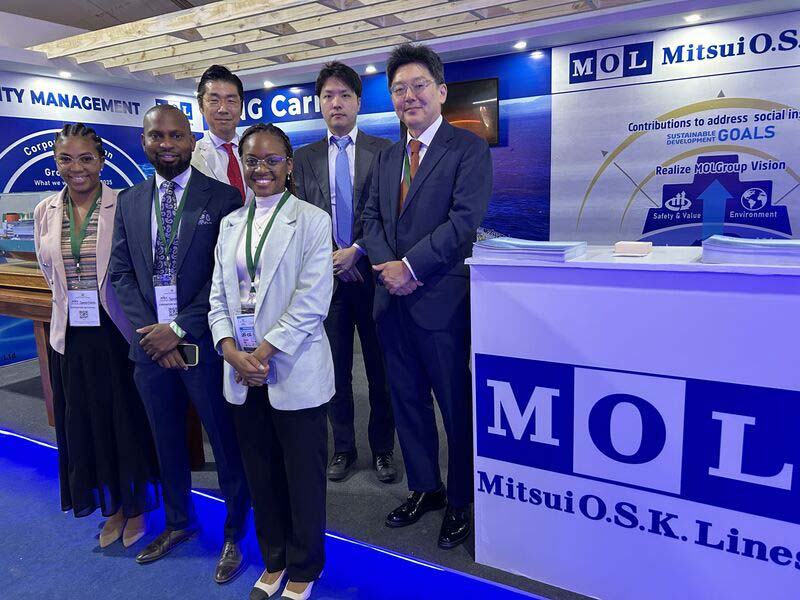 MOL Maputo office team and representatives from MOL (Europe Africa) standing at an exhibition booth during FACIM 2024, with MOL branding and sustainability messaging displayed in the background.