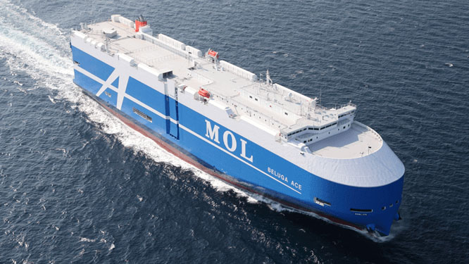 MOL car carrier vessel Beluga Ace sailing at sea, viewed from above, transporting vehicles with its large enclosed deck structure.