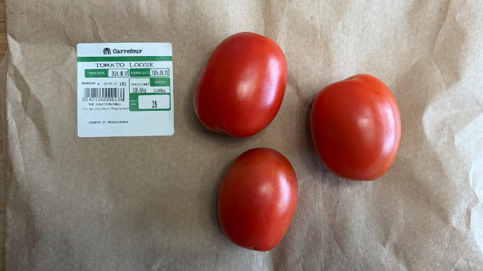 Three tomatoes with a supermarket price label in Nairobi