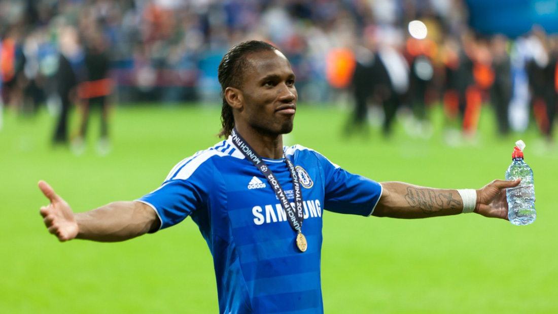 Former Chelsea footballer Drogba wearing a winners’ medal on the pitch after a major European final
