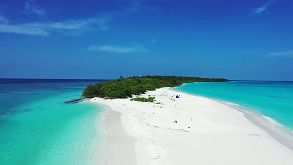 White sandy beach surrounded by turquoise waters along Mozambique’s tropical coastline