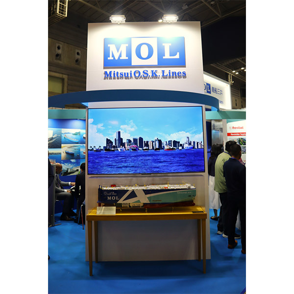 A booth of Mitsui O.S.K. Lines (MOL) at TICAD 9, featuring a large screen showing a seaport skyline and a detailed ship model displayed below.